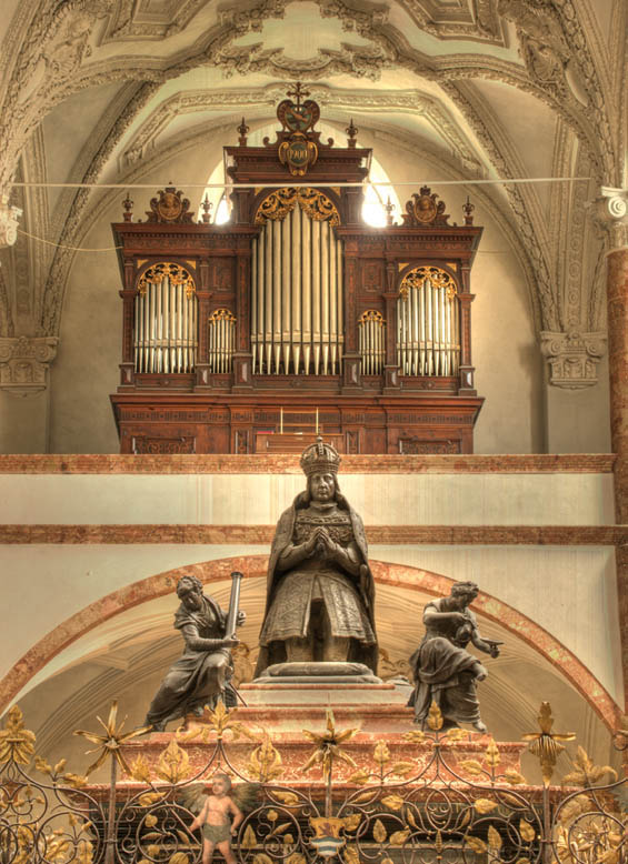 Der zum Hauptalter hin knieende Maximilian berragt auch aus Bronze gegossene Figuren, die die vier Kardinaltugenden darstellen.